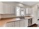 Bright kitchen features a stainless steel dishwasher, sink, and plentiful white cabinets at 7012 Mercurio Ave, Las Vegas, NV 89131