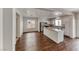 Bright, open-concept living space with wood floors, seamlessly flowing into the kitchen area with ample natural light at 7012 Mercurio Ave, Las Vegas, NV 89131