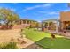 This backyard has a putting green, outdoor kitchen, pergola, and low maintenance desert landscaping at 7354 Strutting Silver Ct, Las Vegas, NV 89131