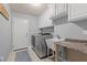 Modern laundry room with utility sink and front loading washer and dryer at 7354 Strutting Silver Ct, Las Vegas, NV 89131