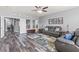 Open living room with hardwood floors, ceiling fan, leather sofas, and natural light at 7354 Strutting Silver Ct, Las Vegas, NV 89131