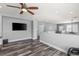 Open loft space with hardwood floors, neutral paint, ceiling fan, and a wall-mounted television at 7354 Strutting Silver Ct, Las Vegas, NV 89131