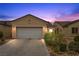 Charming single-story home with well-maintained landscaping and a two-car garage under a colorful sunset at 7849 Lily Trotter St, North Las Vegas, NV 89084