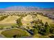 Scenic aerial of the golf course with lush green fairways, trees, and views of the mountains at 7849 Lily Trotter St, North Las Vegas, NV 89084