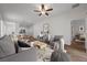 Bright living room with wood-look tile flooring, neutral walls, ceiling fan, and modern furnishings at 7849 Lily Trotter St, North Las Vegas, NV 89084