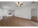 Bright and open living area with wood-look tile flooring, ceiling fan, and access to the kitchen and hallway at 7849 Lily Trotter St, North Las Vegas, NV 89084