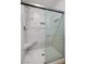 Modern shower with glass door, tiled walls, and built-in seat for a luxurious bathing experience at 7849 Lily Trotter St, North Las Vegas, NV 89084