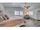 Bright primary bedroom with a ceiling fan, wood-look flooring, and ample natural light at 8073 Villa Pulido St, Las Vegas, NV 89131