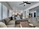 Open-concept living room with kitchen and dining views, showcasing a large sectional sofa and wood-look tile floors at 8073 Villa Pulido St, Las Vegas, NV 89131