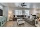 Bright living room featuring a large sectional sofa, shuttered windows, and modern ceiling fan at 8073 Villa Pulido St, Las Vegas, NV 89131