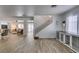 Spacious open-concept living area with wood-look tile flooring and stairway at 8073 Villa Pulido St, Las Vegas, NV 89131