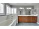 Primary bathroom with a large soaking tub, vanity with double sinks, and light-filled window at 8287 Lincoln Valley St, Las Vegas, NV 89123