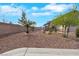 Desert landscaped front yard with low-maintenance plants, rocks, and trees, creating a welcoming entrance at 8287 Lincoln Valley St, Las Vegas, NV 89123