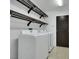 Laundry room with washer, dryer, tile floor and upper shelving at 8287 Lincoln Valley St, Las Vegas, NV 89123