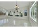 Bright living room with modern chandelier, custom shelving and shuttered windows at 8287 Lincoln Valley St, Las Vegas, NV 89123