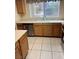 Functional kitchen with stainless steel dishwasher, window view, and wood cabinetry at 830 Carnegie St # 1811, Henderson, NV 89052