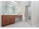 Bright bathroom featuring a wooden vanity with double sinks and a separate shower with glass doors at 8904 Marble Dr, Las Vegas, NV 89134