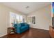 Bright living room with a blue sofa, wood floors, and view to the neighborhood through the windows at 8904 Marble Dr, Las Vegas, NV 89134