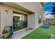 Manicured backyard with artificial turf, patio, and sliding glass door access at 10004 Pasque Flower Ct, Las Vegas, NV 89178