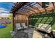 Charming backyard with a pergola-covered patio, outdoor seating, and manicured lawn for relaxation at 10004 Pasque Flower Ct, Las Vegas, NV 89178