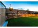 Beautiful backyard with manicured artificial turf, retaining wall with garden lighting and vibrant greenery at 10125 Sequoia Falls Pl, Las Vegas, NV 89149