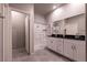 Modern bathroom with a double vanity, a glass-enclosed shower, and sleek tile flooring at 10125 Sequoia Falls Pl, Las Vegas, NV 89149