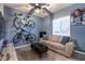 A cozy bedroom featuring blue walls, a ceiling fan, and two bicycles hung as decorative art at 10125 Sequoia Falls Pl, Las Vegas, NV 89149