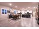 Open-concept dining area with kitchen featuring tile floors, modern fixtures, and ample seating at island at 10125 Sequoia Falls Pl, Las Vegas, NV 89149