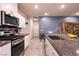 Chic kitchen with white cabinets, granite countertops, stainless steel appliances, and a sleek sink at 10125 Sequoia Falls Pl, Las Vegas, NV 89149