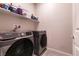 Modern laundry room with Samsung washer and dryer, plus storage shelf above at 10125 Sequoia Falls Pl, Las Vegas, NV 89149