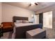 Spacious main bedroom with a dark gray bed frame, a tufted ottoman and an ensuite bathroom at 10125 Sequoia Falls Pl, Las Vegas, NV 89149