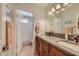 Well-lit bathroom featuring double sinks with a granite countertop and a shower with glass doors at 1022 Atticus Ave, Henderson, NV 89015
