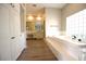 Bathroom with tile floors, double sink vanity, soaking tub, and a glass block window at 2111 Loro Ct, Las Vegas, NV 89117