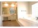 Modern bathroom featuring a jacuzzi, glass block window and sleek vanity at 2111 Loro Ct, Las Vegas, NV 89117