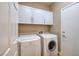 Functional laundry room equipped with modern washer and dryer units, plus white storage cabinets at 2217 Merrimack Valley Ave, Henderson, NV 89044
