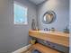 Contemporary bathroom with a floating wood vanity, unique mirror, and stylish fixtures at 261 W Cypress Dr, Henderson, NV 89015