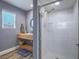 Modern bathroom featuring a shower with a glass door, floating sink, and window at 261 W Cypress Dr, Henderson, NV 89015