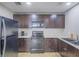 Well-equipped kitchen featuring a range, microwave, dark cabinetry and light-colored countertops at 261 W Cypress Dr, Henderson, NV 89015