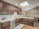 Bright kitchen with dark wood cabinets, stainless appliances and a large skylight overhead at 261 W Cypress Dr, Henderson, NV 89015