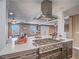 Kitchen island boasts stainless cooktop, oven, and stylish range hood with open floorplan at 261 W Cypress Dr, Henderson, NV 89015