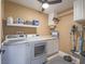 Functional laundry room with modern washer and dryer, storage shelves, and ample counter space at 261 W Cypress Dr, Henderson, NV 89015