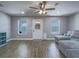 Bright living room with two windows, ceiling fan, hardwood floors and comfortable gray sectional sofa at 261 W Cypress Dr, Henderson, NV 89015
