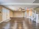 Expansive living room with hardwood floors, fan and staircase with entry at 261 W Cypress Dr, Henderson, NV 89015