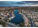 Stunning aerial view of a residential community with a lake and mountain backdrop at 2617 Huber Heights Dr, Las Vegas, NV 89128