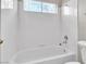 Bathroom featuring a white bathtub with tiled walls and a toilet at 2617 Huber Heights Dr, Las Vegas, NV 89128