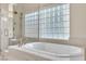 Soaking tub in primary bathroom with glass block window and updated fixtures at 2617 Huber Heights Dr, Las Vegas, NV 89128