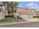 Charming two-story home showcasing a three-car garage, well-manicured lawn, and mature trees at 2617 Huber Heights Dr, Las Vegas, NV 89128
