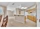 Open-concept kitchen featuring tile flooring, wood cabinets, a breakfast bar, and views of the living room at 2617 Huber Heights Dr, Las Vegas, NV 89128