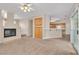 Inviting living room featuring neutral carpet, built-in shelving, fireplace and bar access to kitchen at 2617 Huber Heights Dr, Las Vegas, NV 89128