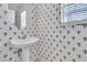 Stylish powder room showcasing unique wallpaper, a pedestal sink, and a mirror at 2617 Huber Heights Dr, Las Vegas, NV 89128